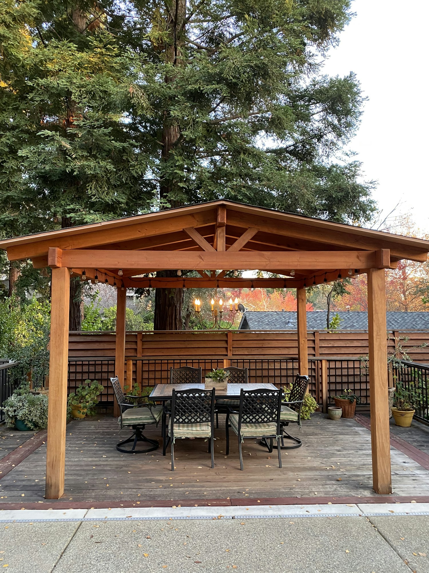 decking & pergola,A chandelier hangs under a backyard pergola designed for luxury dining and outdoor entertainment