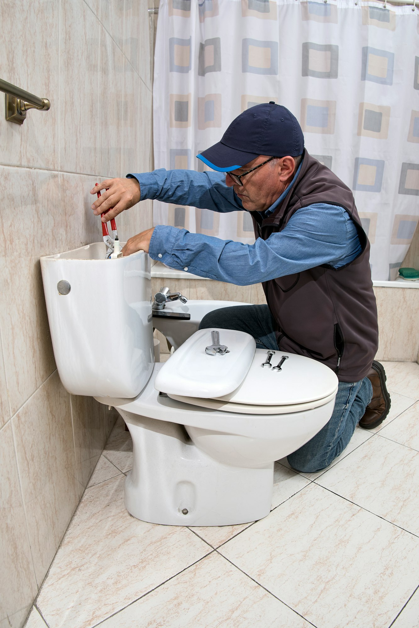 Plumber repairing a toilet cistern