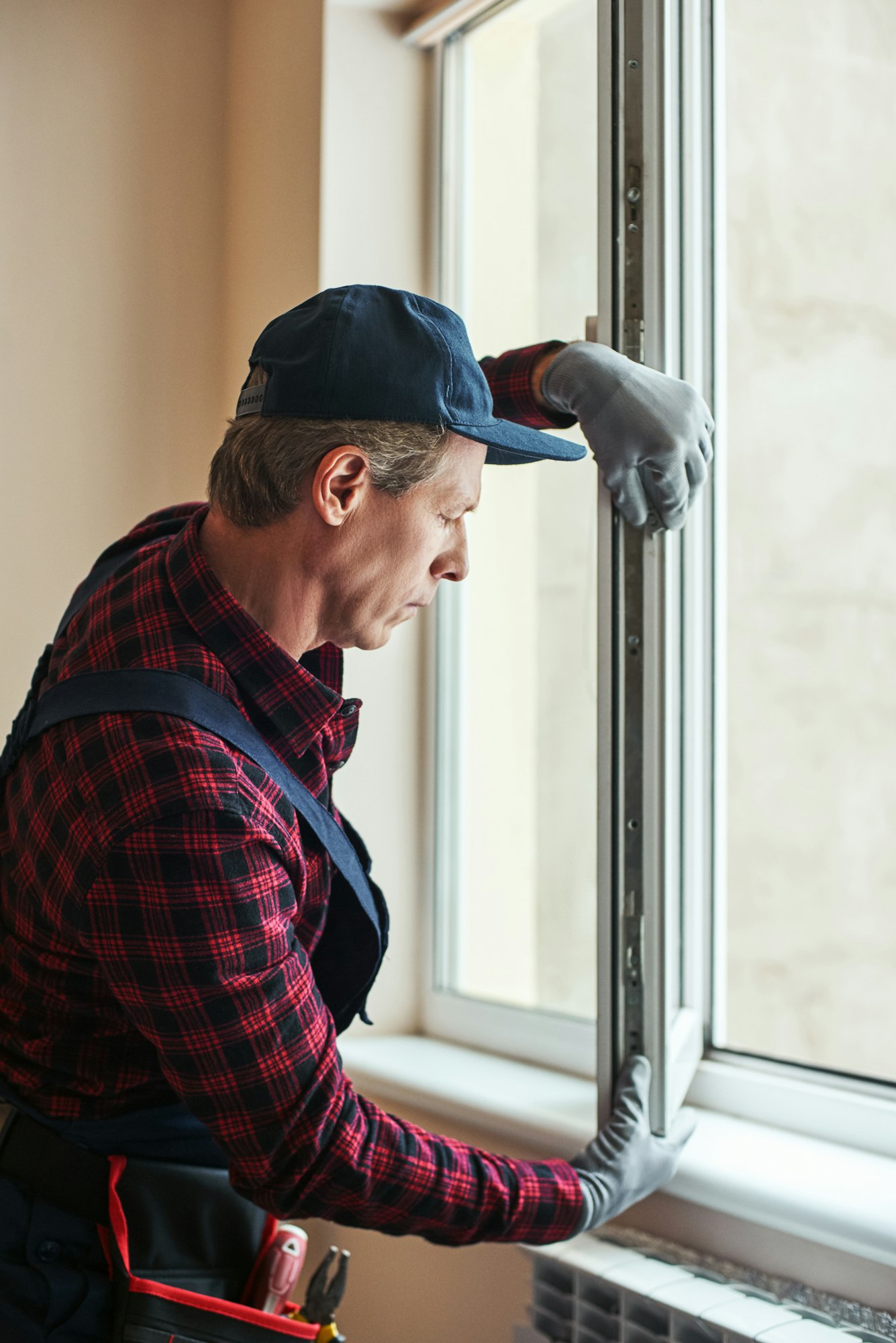 Quality skills. Side view of senior handyman setting new windows